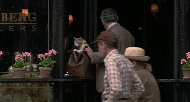 Wide shot frame from Men in Black — sitting, standing, bag
