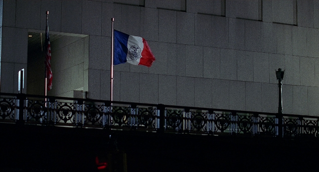 Wide shot frame from Men in Black — flag, night, glass