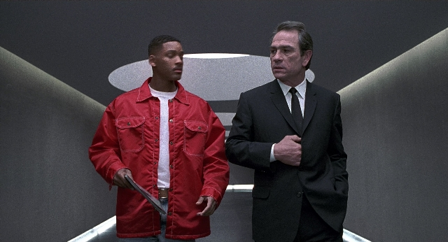 Wide shot frame from Men in Black — standing, hand, suit