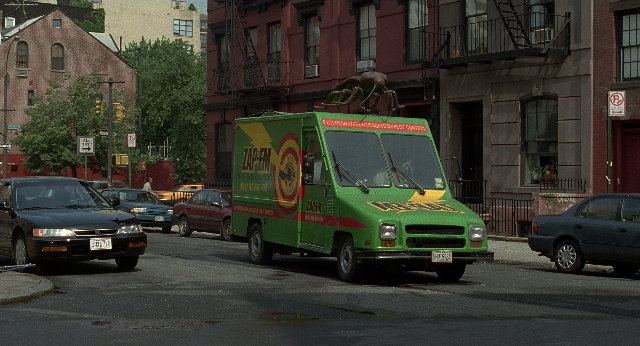 Wide shot frame from Men in Black — street, car, food