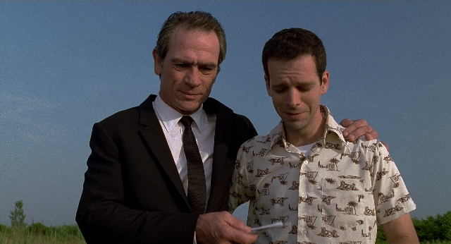 Wide shot frame from Men in Black — standing, hand, suit