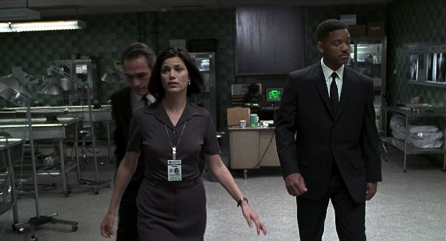 Wide shot frame from Men in Black — walking, suit, tie