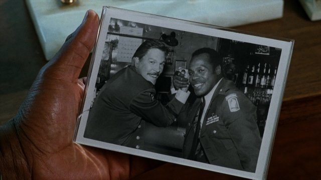 Wide shot frame from Lethal Weapon — standing, kitchen, hand