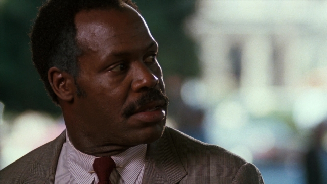 Close-up frame from Lethal Weapon — suit, tie, mustache