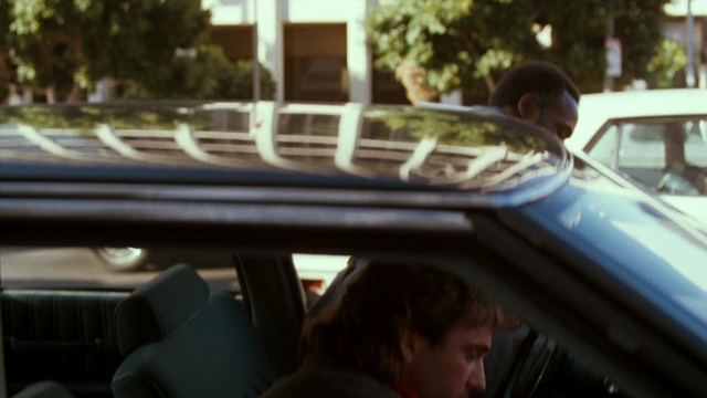Frame from Lethal Weapon — sitting, street, car