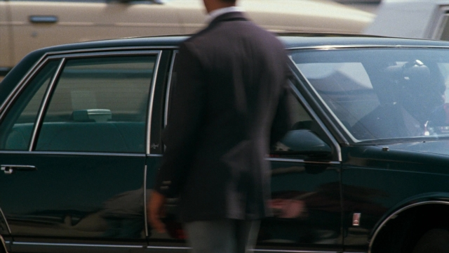 Frame from Lethal Weapon — walking, car, suit