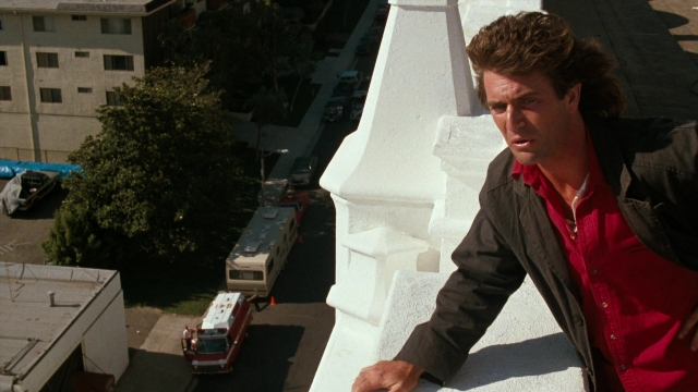 Wide shot frame from Lethal Weapon — standing, dialogue, street