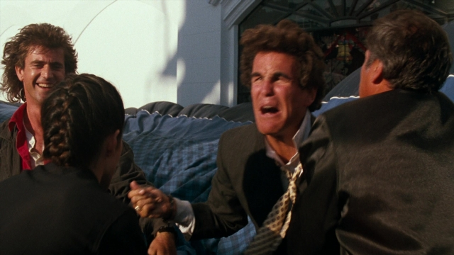 Wide shot frame from Lethal Weapon — sitting, room, dialogue