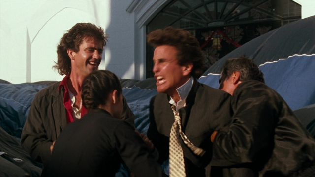 Wide shot frame from Lethal Weapon — room, dialogue, suit