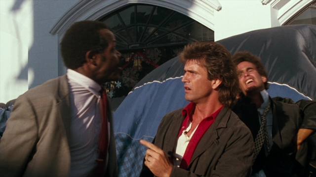 Wide shot frame from Lethal Weapon — standing, room, hand