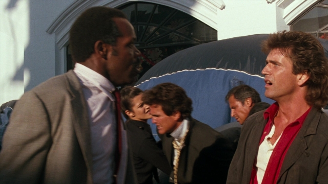 Frame from Lethal Weapon — standing, dialogue, suit