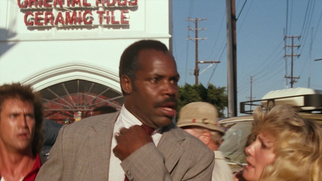 Wide shot frame from Lethal Weapon — standing, street, suit