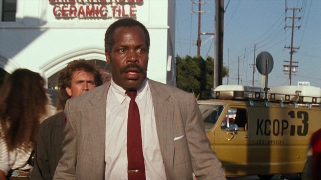 Wide shot frame from Lethal Weapon — walking, street, suit