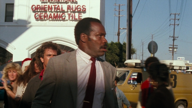 Wide shot frame from Lethal Weapon — walking, street, suit