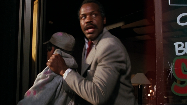 Medium shot frame from Lethal Weapon — standing, hat, suit
