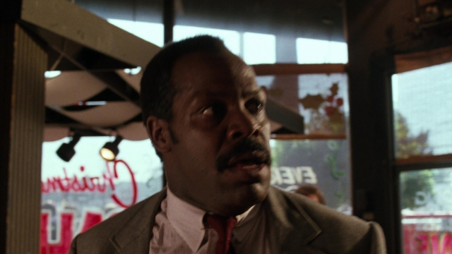Wide shot frame from Lethal Weapon — suit, tie, restaurant