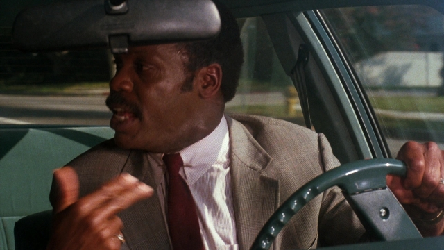 Wide shot frame from Lethal Weapon — sitting, street, car