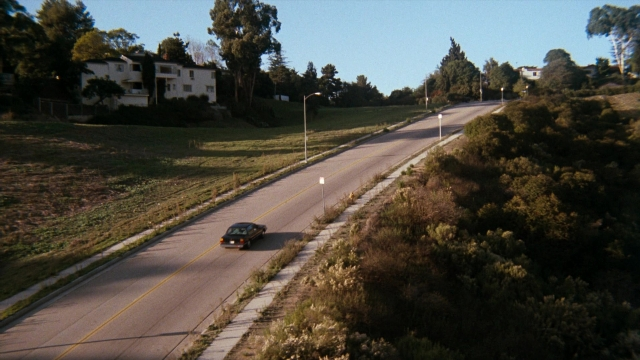 Wide shot frame from Lethal Weapon — street, car, land vehicle