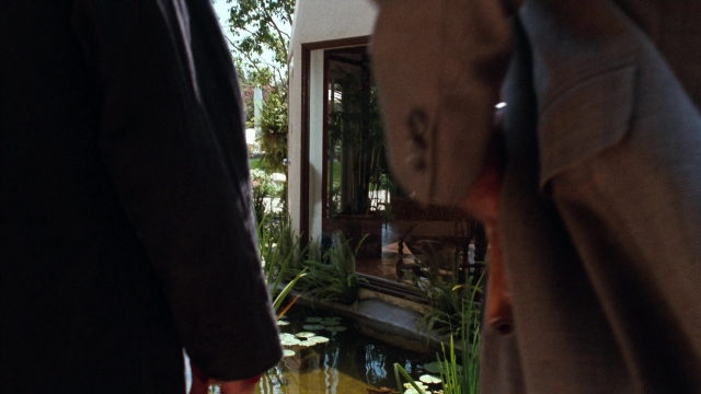 Wide shot frame from Lethal Weapon — standing, coat, hand
