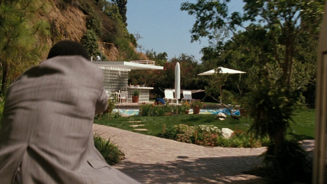 Wide shot frame from Lethal Weapon — sitting, suit, umbrella