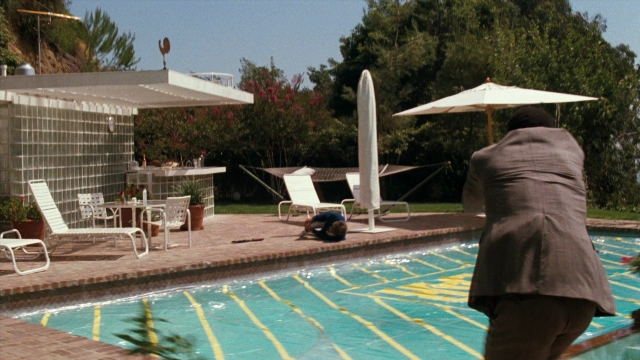Wide shot frame from Lethal Weapon — standing, table, suit