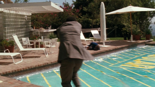 Wide shot frame from Lethal Weapon — walking, table, suit