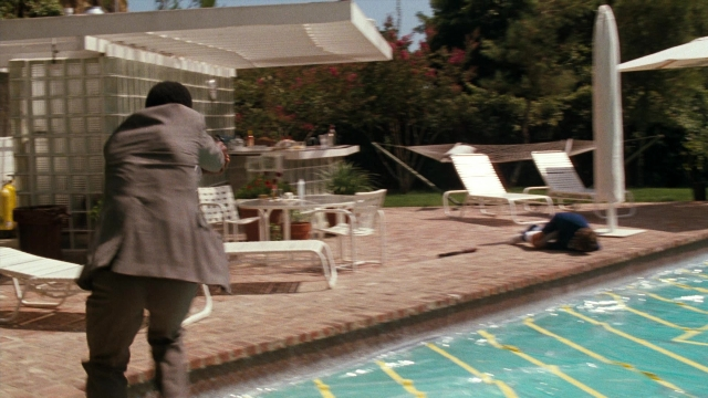 Wide shot frame from Lethal Weapon — standing, table, fire
