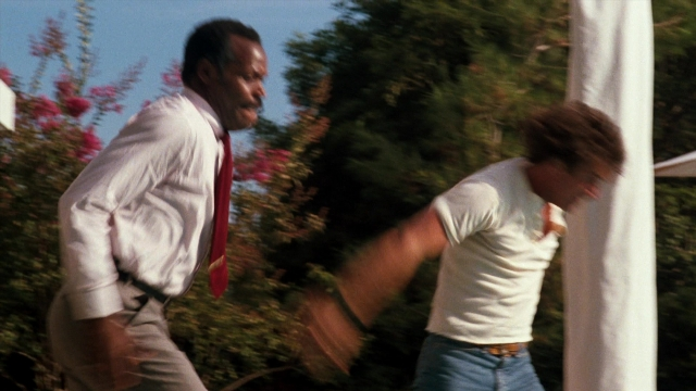 Wide shot frame from Lethal Weapon — standing, dialogue, hand