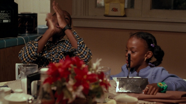 Frame from Lethal Weapon — sitting, standing, table