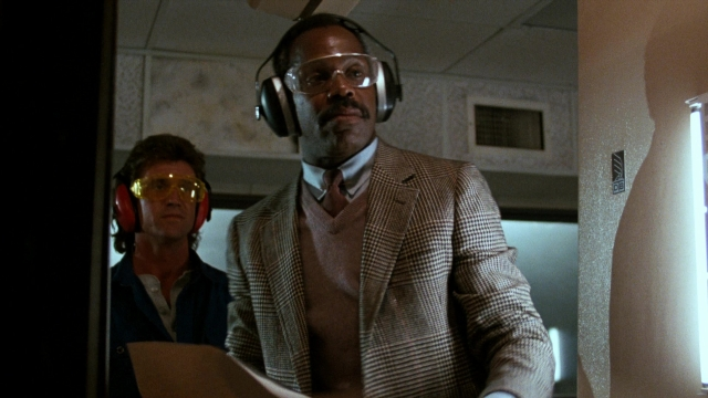 Wide shot frame from Lethal Weapon — room, hand, suit