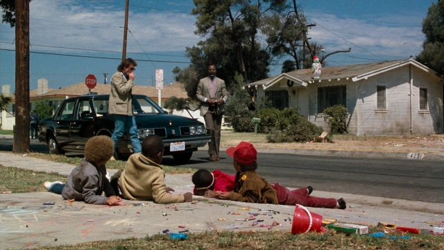Wide shot frame from Lethal Weapon — standing, street, car
