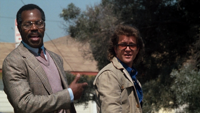 Wide shot frame from Lethal Weapon — standing, street, hand