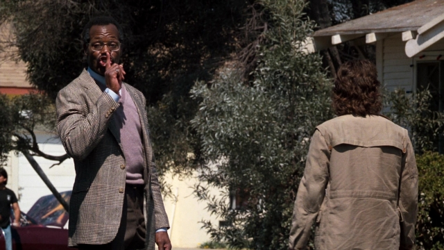 Wide shot frame from Lethal Weapon — walking, street, car