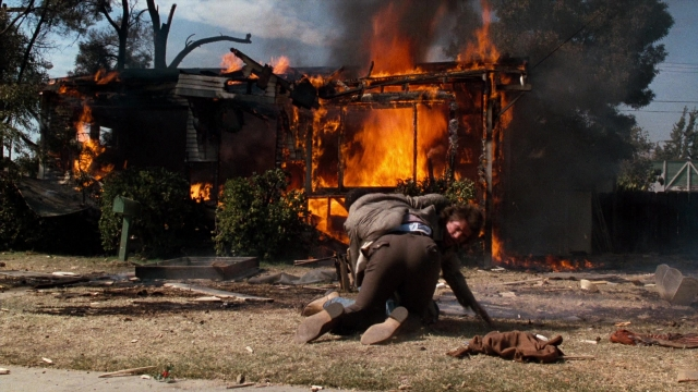 Wide shot frame from Lethal Weapon — fire, hand, bag