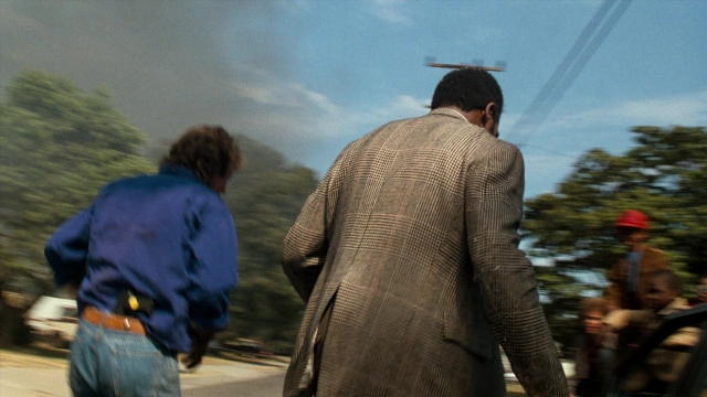 Frame from Lethal Weapon — walking, street, hat