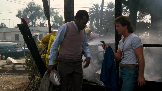 Wide shot frame from Lethal Weapon — standing, dialogue, street