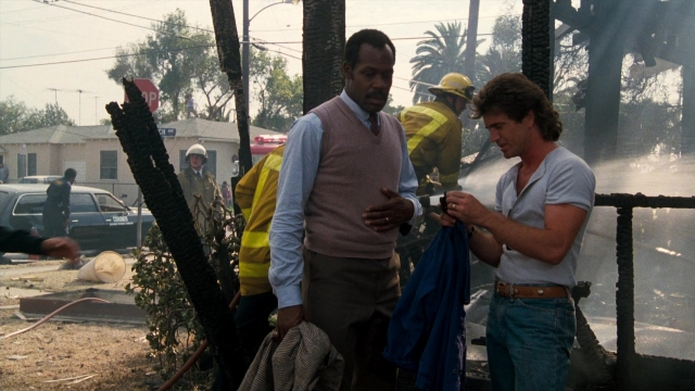 Wide shot frame from Lethal Weapon — standing, fire, car