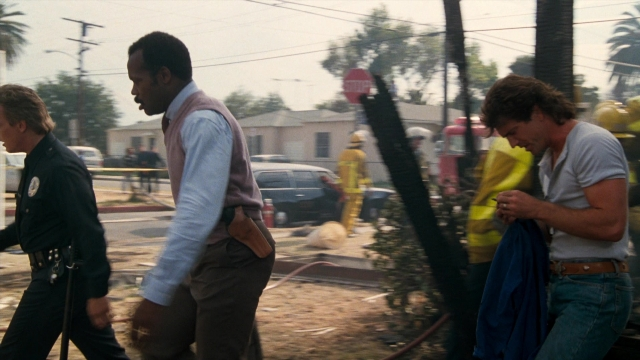 Wide shot frame from Lethal Weapon — walking, street, uniform