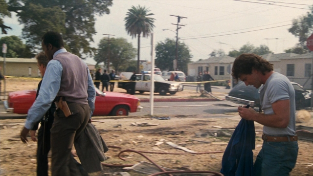 Wide shot frame from Lethal Weapon — walking, street, car