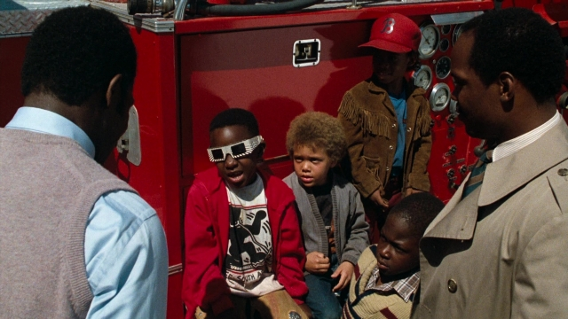 Wide shot frame from Lethal Weapon — standing, hat, fire