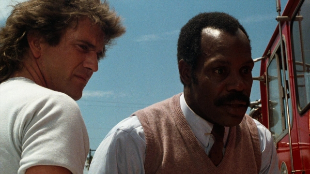 Wide shot frame from Lethal Weapon — standing, fire, shirt