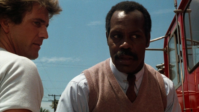 Medium shot frame from Lethal Weapon — standing, street, fire
