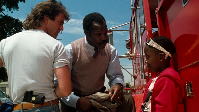 Frame from Lethal Weapon — standing, dialogue, street