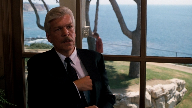 Wide shot frame from Lethal Weapon — standing, suit, tie