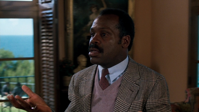Wide shot frame from Lethal Weapon — sitting, room, table