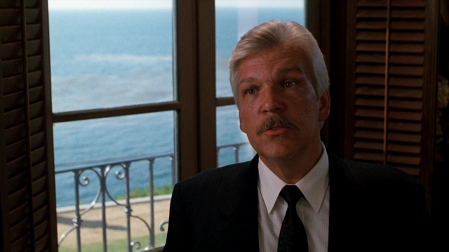 Close-up frame from Lethal Weapon — standing, suit, tie