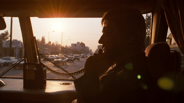 Wide shot frame from Lethal Weapon — sitting, dialogue, phone