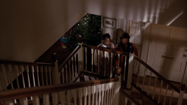 Wide shot frame from Lethal Weapon — standing, room, door