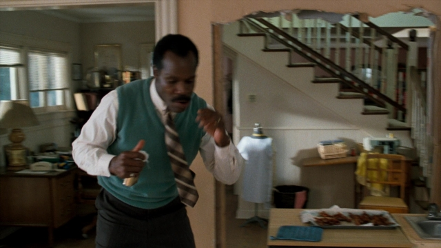 Wide shot frame from Lethal Weapon — standing, plate, table