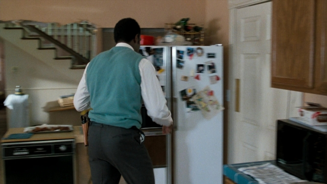 Wide shot frame from Lethal Weapon — standing, kitchen, refrigerator